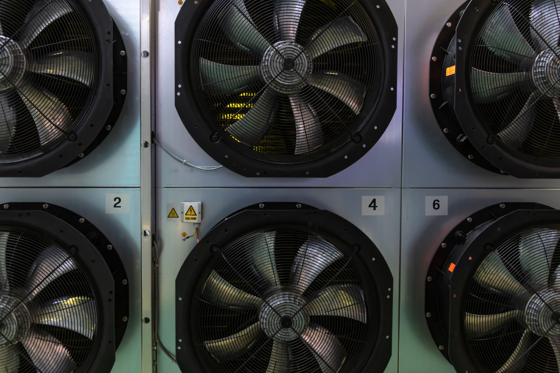 Industrial cooling fans mounted on a wall in a modern facility