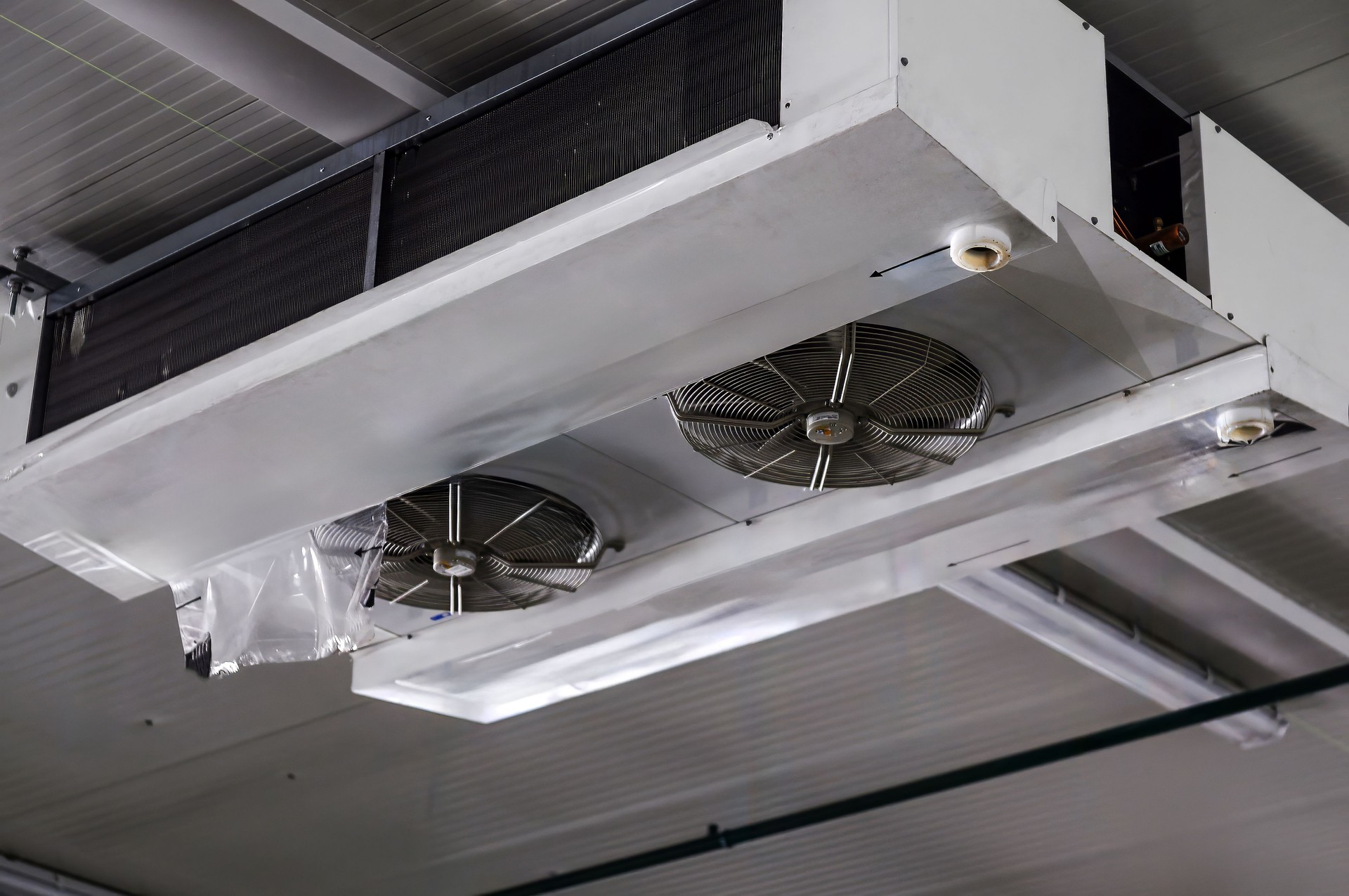Industrial air cooler and ceiling-mounted refrigeration unit for temperature control in large spaces.